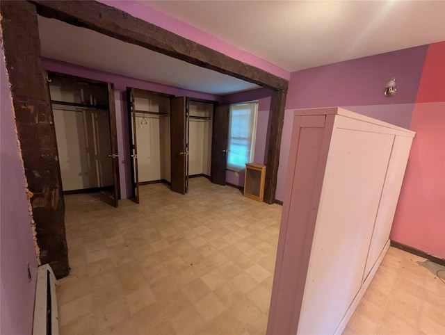 265 Goodwill Rd, Montgomery, NY 12549 - unfurnished bedroom with light flooring, a baseboard radiator, and two closets