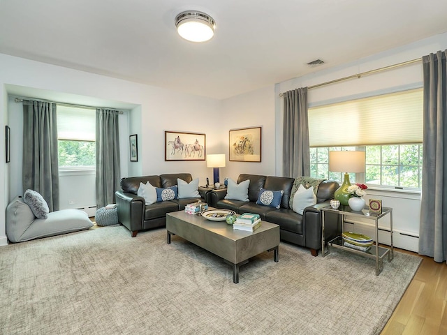 70 Scudders Ln, Roslyn Harbor, NY 11576 - living area featuring healthy amount of natural light, wood finished floors, and a baseboard radiator