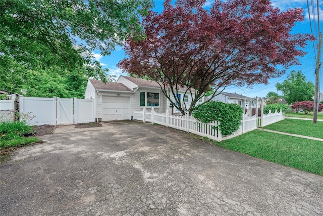 167 Front Ave, Brentwood, NY 11717 - view of front of house featuring asphalt driveway, a garage, a fenced front yard, and a gate