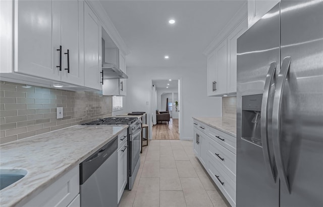 167 Front Ave, Brentwood, NY 11717 - kitchen with appliances with stainless steel finishes, recessed lighting, white cabinetry, tasteful backsplash, and light stone countertops