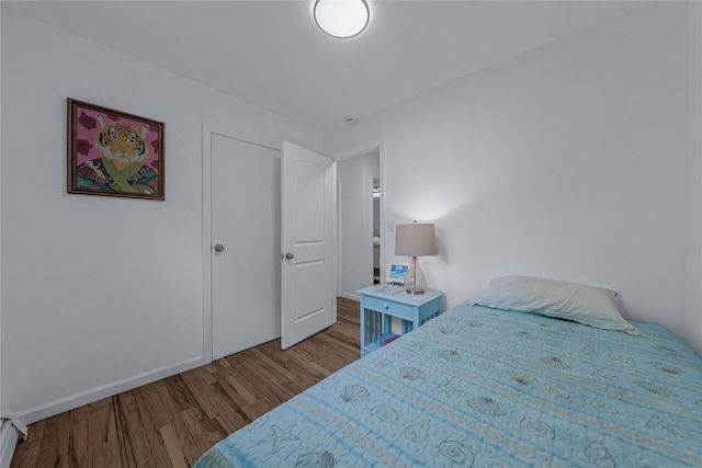 167 Front Ave, Brentwood, NY 11717 - bedroom featuring wood finished floors and a baseboard heating unit