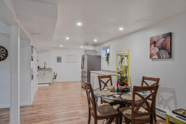 69 Plum St, Central Islip, NY 11722 - dining area with light wood-style flooring, recessed lighting, baseboards, and a baseboard heating unit