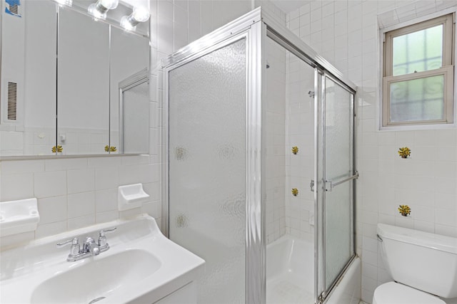 48-25 43rd St Unit 1J, Woodside, NY 11377 - bathroom with tile walls, toilet, vanity, and combined bath / shower with glass door