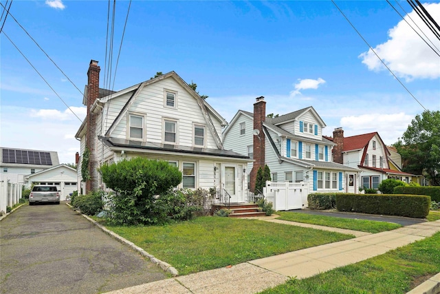 109 Leverich St, Hempstead, NY 11550 - dutch colonial featuring a gambrel roof, a garage, an outbuilding, and a chimney