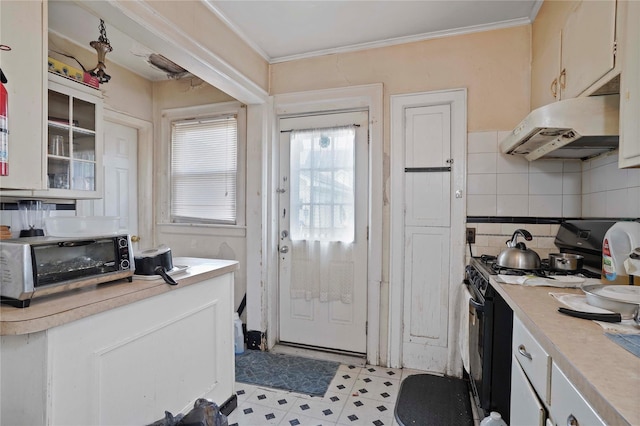 109 Leverich St, Hempstead, NY 11550 - kitchen with under cabinet range hood, gas stove, light countertops, decorative backsplash, and light flooring