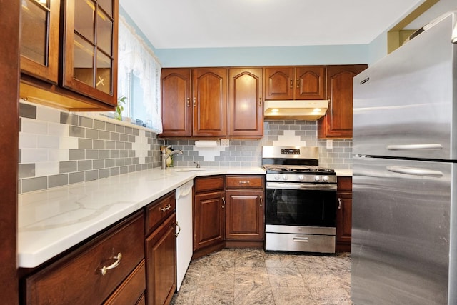80-04 Cowles Ct, Middle Village, NY 11379 - kitchen featuring appliances with stainless steel finishes, under cabinet range hood, light countertops, glass insert cabinets, and backsplash