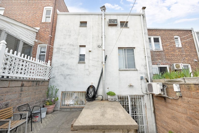 80-04 Cowles Ct, Middle Village, NY 11379 - rear view of house featuring stucco siding, a patio area, and cooling unit