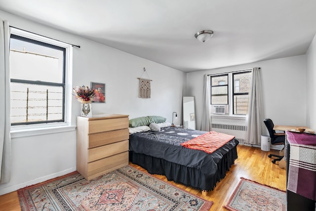 2420 Morris Ave Unit 5J, Bronx, NY 10468 - bedroom featuring radiator heating unit, light wood-style floors, an office area, and cooling unit