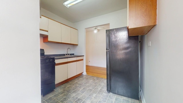 66-15 Wetherole St Unit E16, Rego Park, NY 11374 - kitchen featuring freestanding refrigerator, black gas range, a sink, ceiling fan, and under cabinet range hood