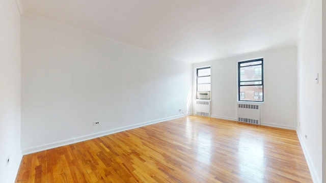 66-15 Wetherole St Unit E16, Rego Park, NY 11374 - spare room featuring radiator heating unit, light wood finished floors, and baseboards