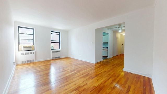 66-15 Wetherole St Unit E16, Rego Park, NY 11374 - empty room featuring radiator, light wood-style flooring, and a ceiling fan