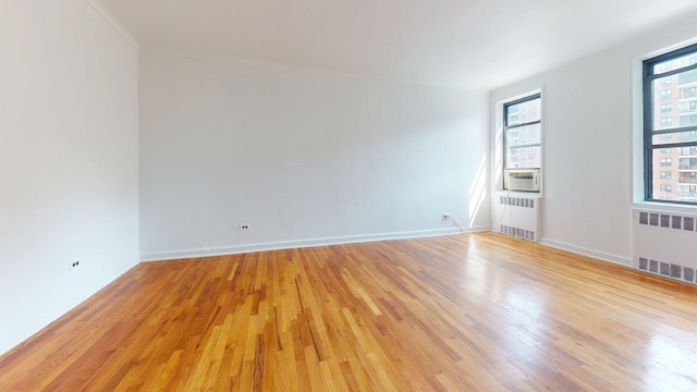 66-15 Wetherole St Unit E16, Rego Park, NY 11374 - unfurnished room with radiator, light wood-style flooring, baseboards, and cooling unit