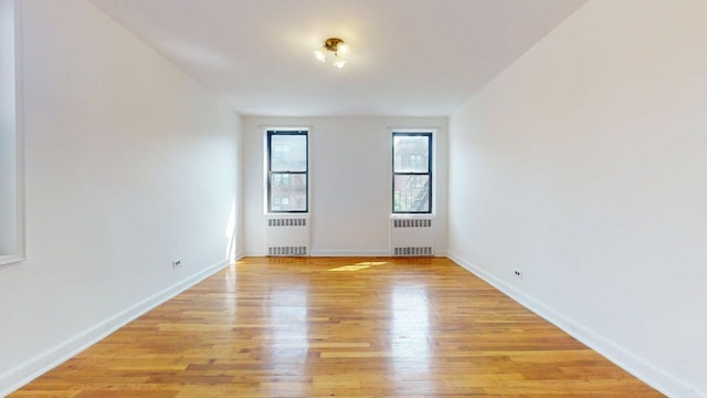 66-15 Wetherole St Unit E16, Rego Park, NY 11374 - unfurnished room featuring radiator, light wood-style floors, and baseboards