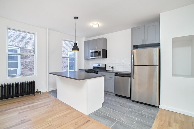 1069 Grant Ave, Bronx, NY 10456 - kitchen featuring appliances with stainless steel finishes, radiator, dark countertops, and gray cabinets