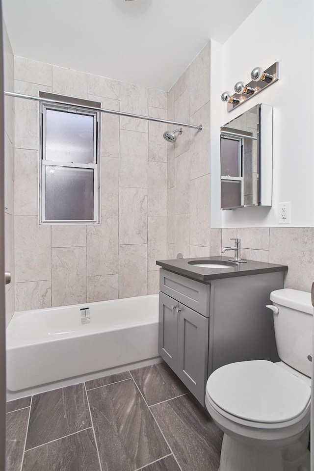 1069 Grant Ave, Bronx, NY 10456 - full bathroom featuring vanity, toilet, tile walls, and shower / bathtub combination
