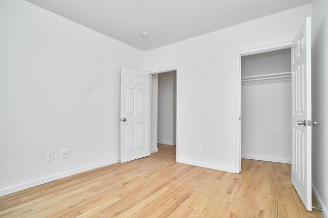 1069 Grant Ave, Bronx, NY 10456 - unfurnished bedroom with light wood-style flooring, a closet, and baseboards