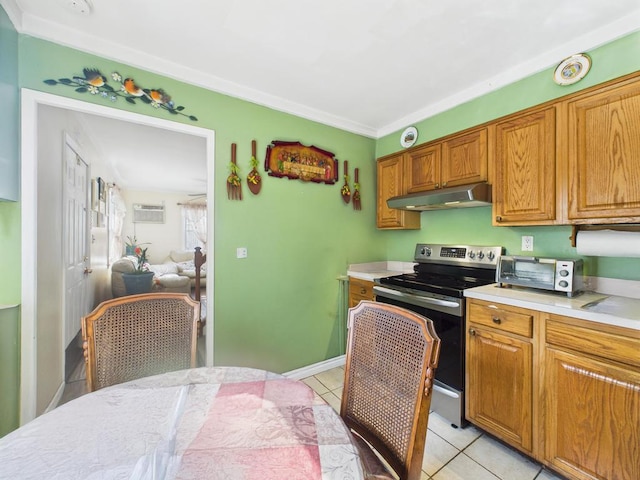 335 Loring Rd, Levittown, NY 11756 - kitchen with stainless steel electric range oven, under cabinet range hood, light tile patterned floors, light countertops, and brown cabinets