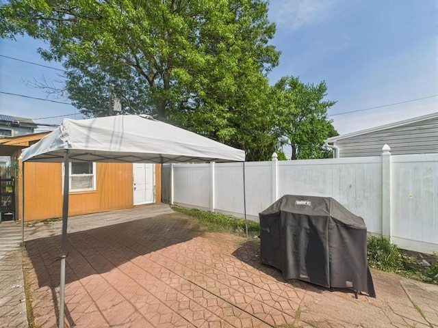 335 Loring Rd, Levittown, NY 11756 - fenced backyard with a detached carport, grilling area, an outbuilding, and a patio