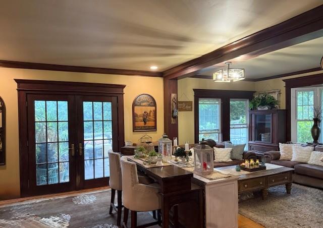 268 Windsor Ave, Brightwaters, NY 11718 - dining space featuring french doors, wood finished floors, crown molding, and a chandelier