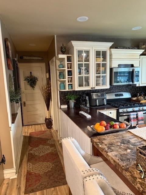 268 Windsor Ave, Brightwaters, NY 11718 - kitchen featuring stainless steel appliances, dark countertops, tasteful backsplash, and wood finished floors