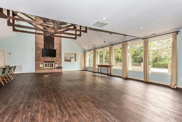 147 The Knl, Syosset, NY 11791 - unfurnished living room featuring a ceiling fan, dark wood finished floors, beamed ceiling, a brick fireplace, and high vaulted ceiling