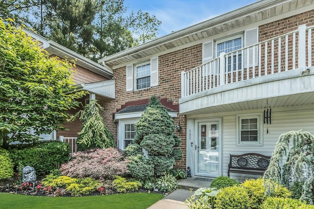 147 The Knl, Syosset, NY 11791 - view of front facade with a balcony and brick siding
