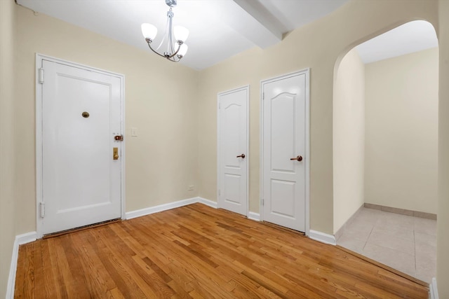 6360 102nd St Unit D8, Rego Park, NY 11374 - foyer entrance with arched walkways, light wood finished floors, baseboards, and a chandelier