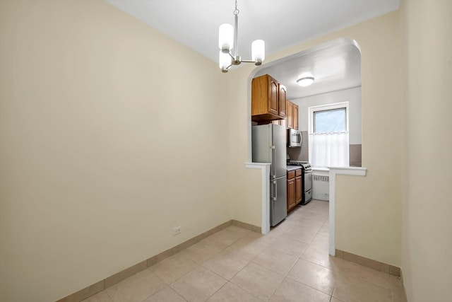 6360 102nd St Unit D8, Rego Park, NY 11374 - kitchen with appliances with stainless steel finishes, arched walkways, light tile patterned floors, light countertops, and brown cabinets
