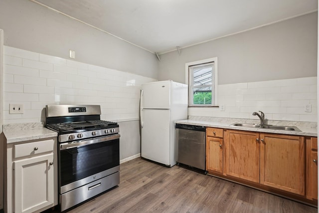 334 Union Ave, Peekskill, NY 10566 - kitchen featuring appliances with stainless steel finishes, dark wood-type flooring, tasteful backsplash, light stone counters, and brown cabinets