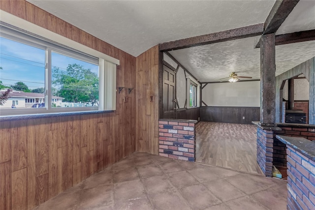 168 Gibbs Rd, Central Islip, NY 11722 - kitchen featuring wood walls, a textured ceiling, healthy amount of natural light, and ceiling fan