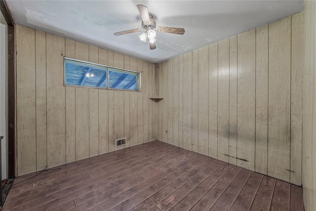 168 Gibbs Rd, Central Islip, NY 11722 - empty room featuring wood finished floors, wood walls, and a ceiling fan