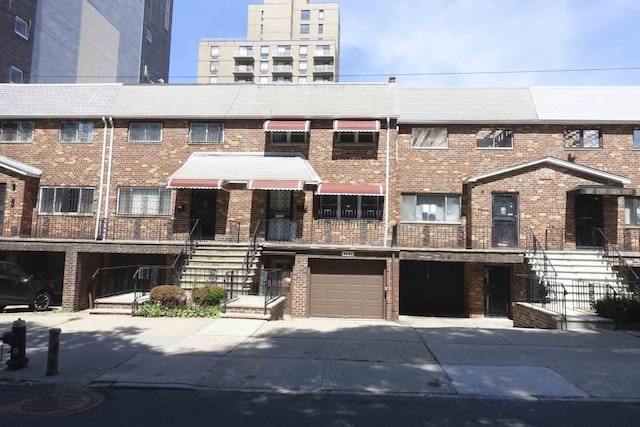 82-91 116th St, Richmond Hill, NY 11418 - view of front facade with driveway, brick siding, a garage, and stairs