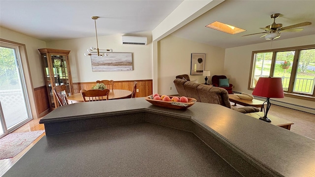 105 White Sulphur Rd, Swan Lake, NY 12783 - dining area with a wall mounted AC, wainscoting, a skylight, wooden walls, and a ceiling fan