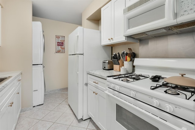 3305 Pine Cone Ct, Poughkeepsie, NY 12603 - kitchen featuring white appliances, stacked washer / drying machine, white cabinets, and light tile patterned flooring