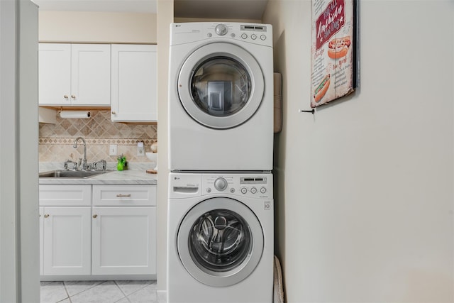 3305 Pine Cone Ct, Poughkeepsie, NY 12603 - laundry area with stacked washing machine and dryer, cabinet space, and light tile patterned floors
