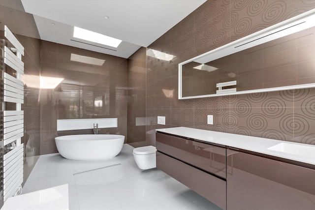 1555 Stevenson Rd, Hewlett, NY 11557 - bathroom with tile walls, a freestanding tub, vanity, and tile patterned flooring