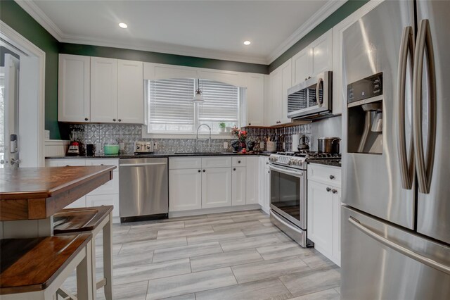163 N Hamilton St, Poughkeepsie, NY 12601 - kitchen featuring appliances with stainless steel finishes, a sink, dark countertops, crown molding, and tasteful backsplash