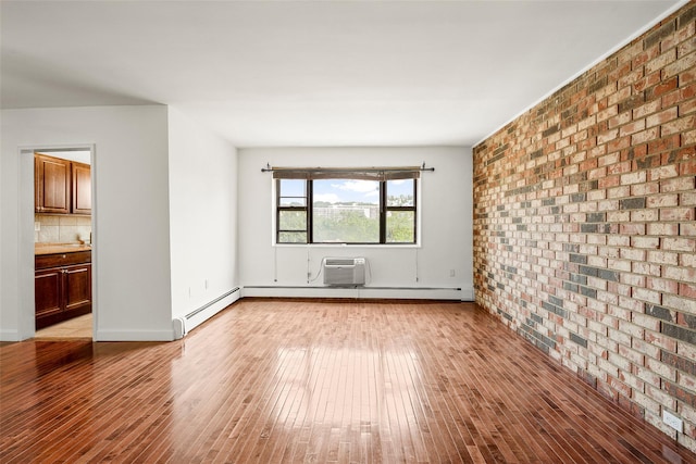 505 Central Ave Unit 609, White Plains, NY 10606 - empty room featuring brick wall, wood finished floors, a baseboard radiator, and a wall mounted air conditioner