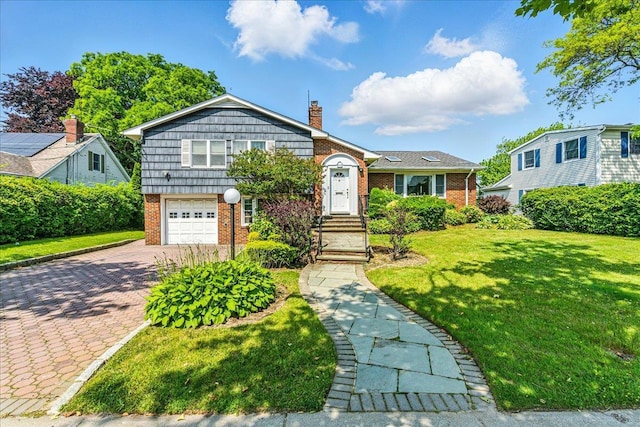189 Blackheath Rd, Lido Beach, NY 11561 - tri-level home with brick siding, a chimney, decorative driveway, a front lawn, and an attached garage