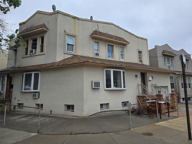 7622 60th Ln, Glendale, NY 11385 - back of property featuring stucco siding, a patio, cooling unit, and a wall mounted AC