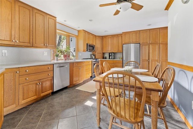 37 Rutland St, Mount Kisco, NY 10549 - kitchen with stainless steel appliances, a ceiling fan, light countertops, dark tile patterned flooring, and brown cabinetry