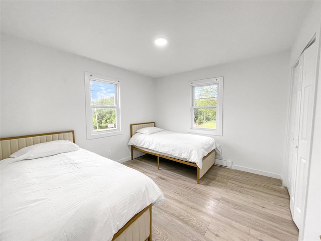 811 Happy Ave, Swan Lake, NY 12783 - bedroom with light wood-type flooring, a closet, baseboards, and a baseboard heating unit