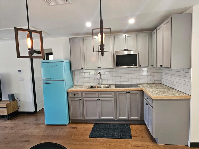 470 Shaver Hill Rd, Andes, NY 13731 - kitchen with freestanding refrigerator, a sink, stainless steel microwave, black electric cooktop, and light countertops