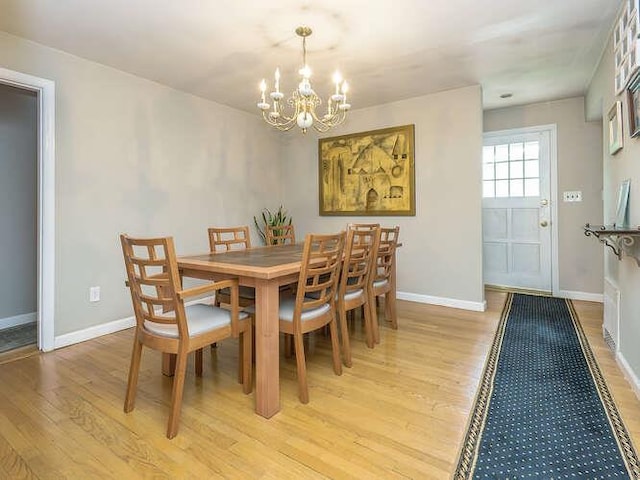 44 Glenwood Rd, Glen Head, NY 11545 - dining space featuring a chandelier, light wood finished floors, and baseboards