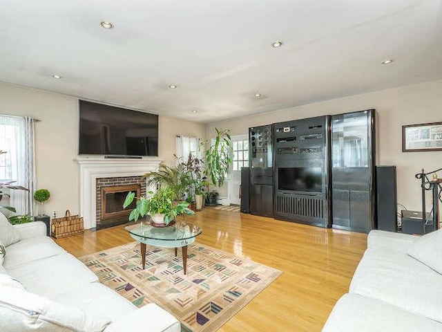 44 Glenwood Rd, Glen Head, NY 11545 - living room featuring wood finished floors, a brick fireplace, and recessed lighting