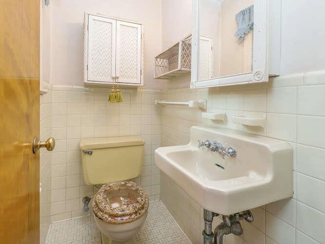 44 Glenwood Rd, Glen Head, NY 11545 - half bathroom with tile walls, toilet, and a sink