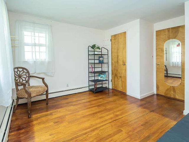 44 Glenwood Rd, Glen Head, NY 11545 - sitting room with arched walkways, wood finished floors, a baseboard heating unit, and a baseboard radiator
