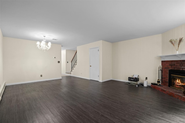 14 Bleakley Dr Unit 14, Peekskill, NY 10566 - unfurnished living room with dark wood finished floors, a brick fireplace, a chandelier, stairway, and baseboard heating