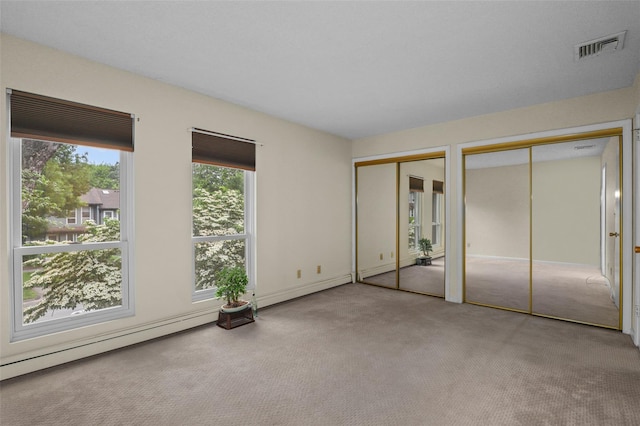 14 Bleakley Dr Unit 14, Peekskill, NY 10566 - unfurnished bedroom featuring carpet, two closets, and a baseboard radiator