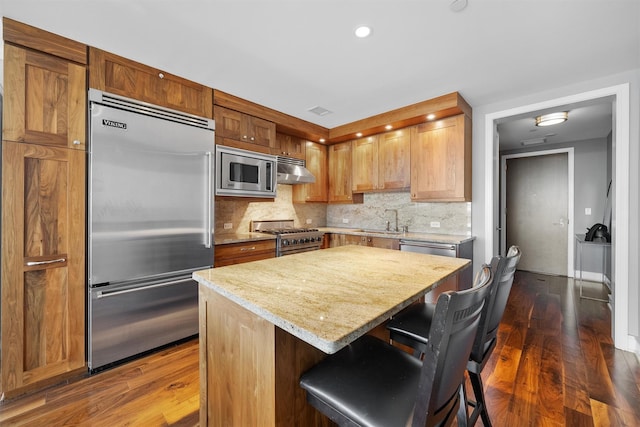 5 Renaissance Sq Unit 23B, White Plains, NY 10601 - kitchen with built in appliances, a sink, backsplash, a center island, and dark wood-style floors